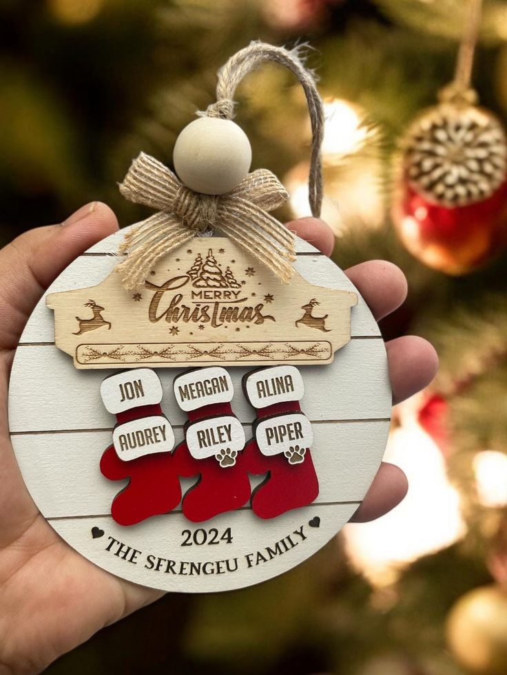 a hand holding a christmas ornament with stockings hanging from it's side