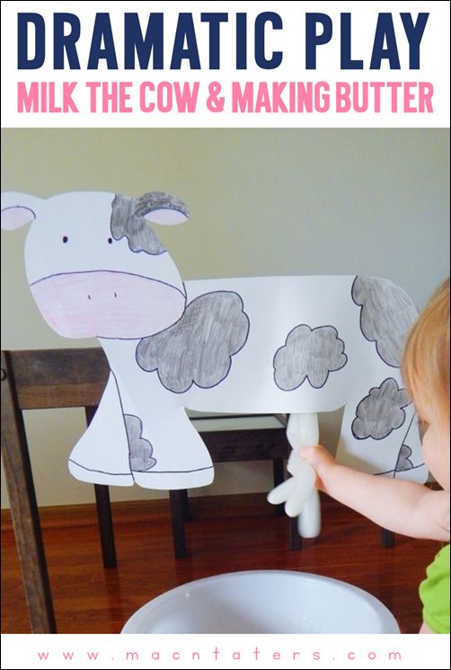 a child playing with a paper cow and making it look like they are eating out of a bowl