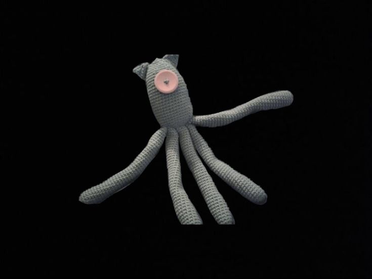 an octopus stuffed animal in the dark with its eyes closed and pink eye patch on it's nose