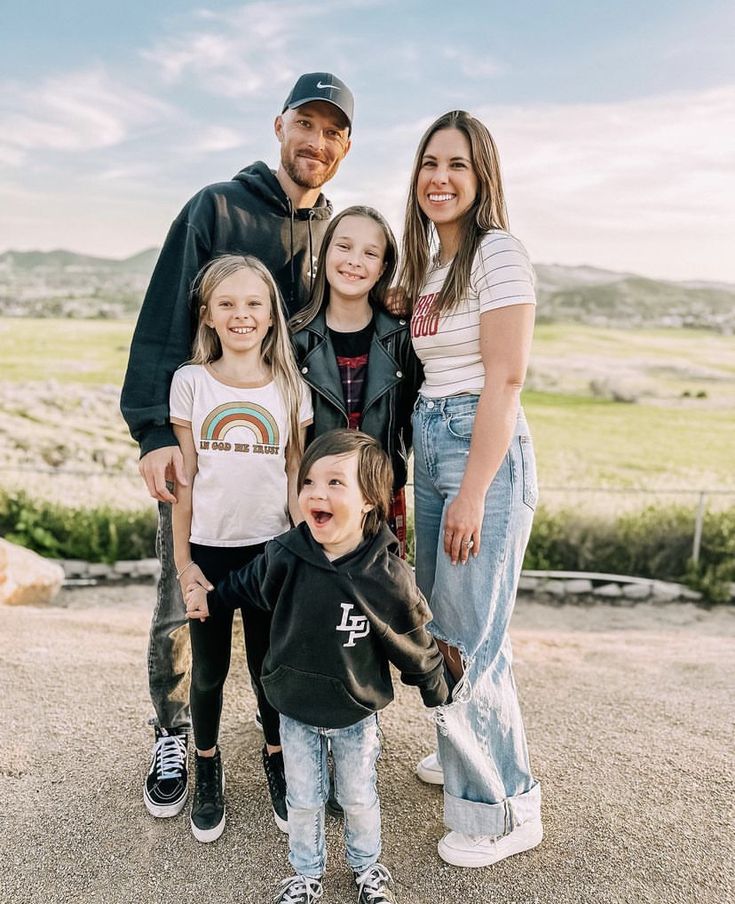 a family poses for a photo in the desert with their child's hand on his hip