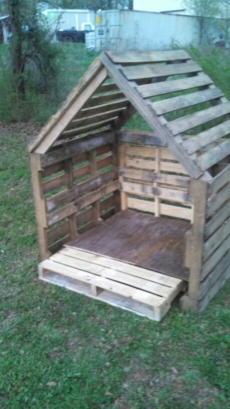 a dog house made out of wooden pallets