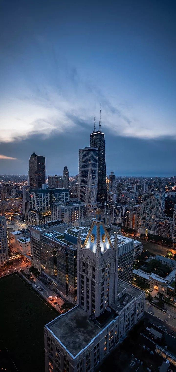 an aerial view of a city at night with skyscrapers and other tall buildings in the background