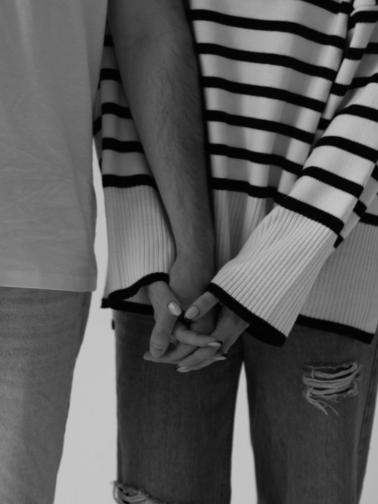 two people holding hands while standing next to each other