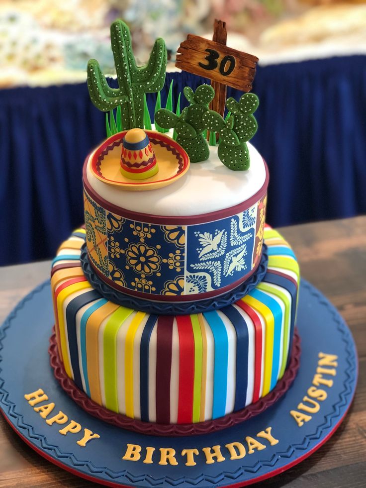 a colorful birthday cake with cactus decorations on top