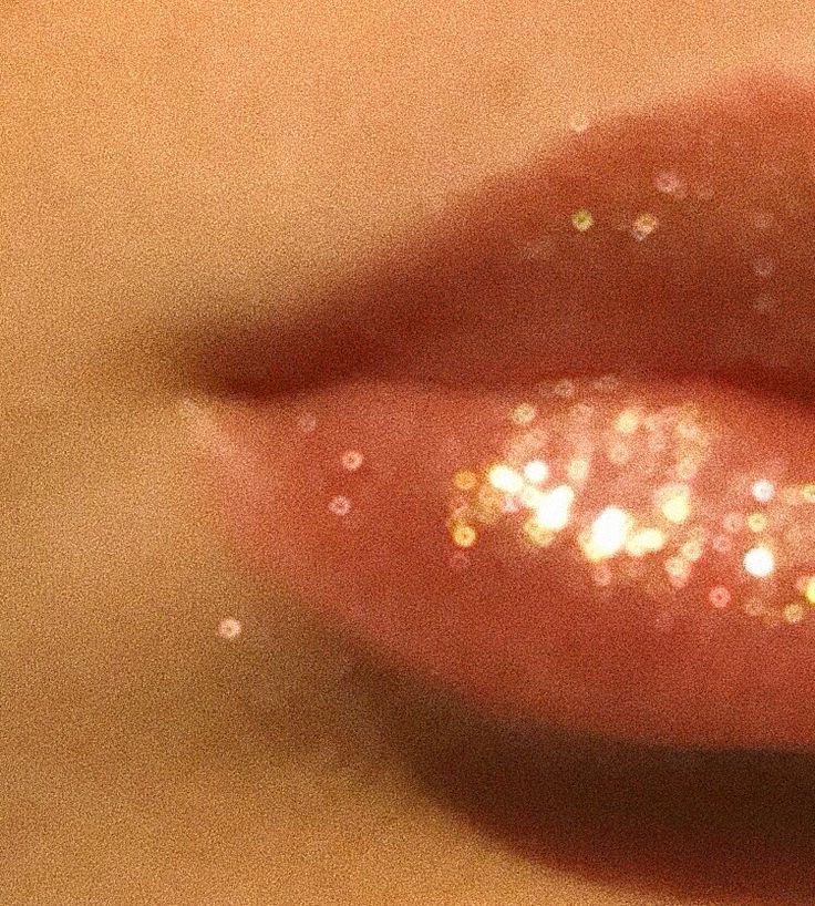 a close up view of a woman's lips with gold glitter on it