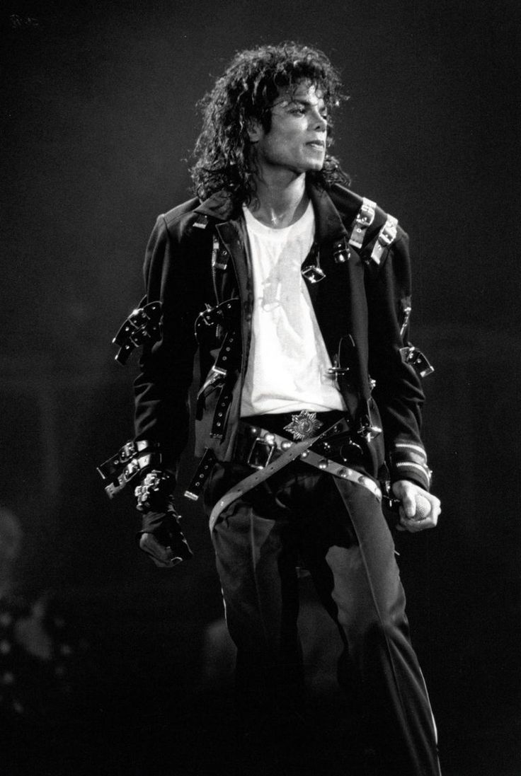 michael jackson performing on stage in black and white with his hair pulled back to the side