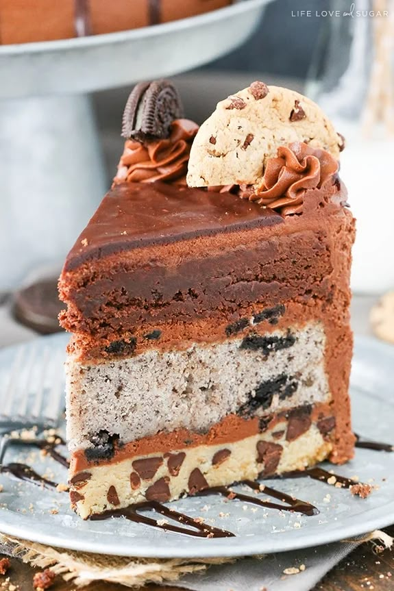 a piece of cake with chocolate and oreo cookies on top is sitting on a plate