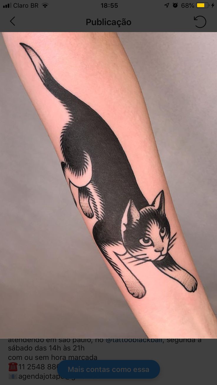 a black and white cat tattoo on the arm