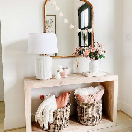 a wooden table topped with baskets next to a mirror