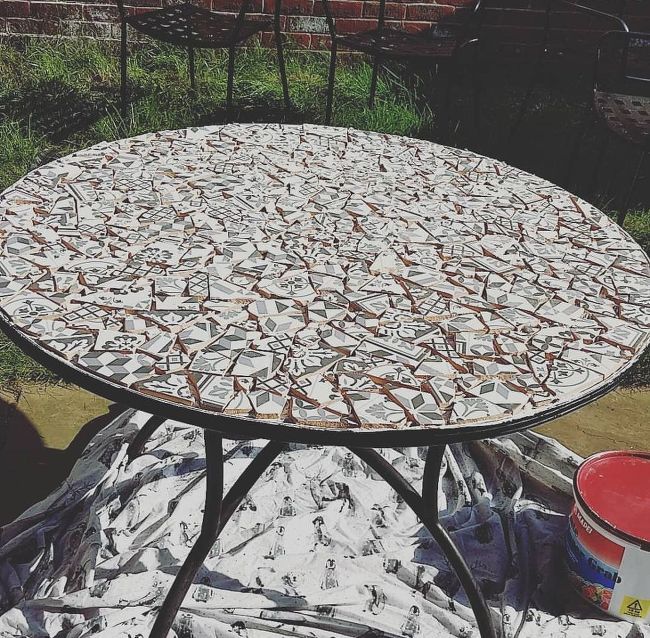 an outdoor table covered in plastic sitting on the ground