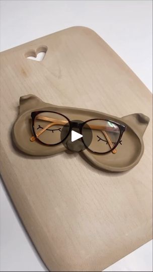 a pair of glasses sitting on top of a cutting board next to an eyeglass case