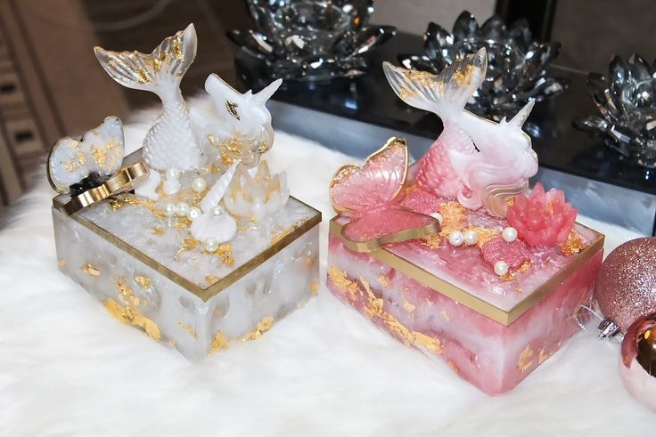 three decorative boxes sitting on top of a white furnishing next to christmas ornaments