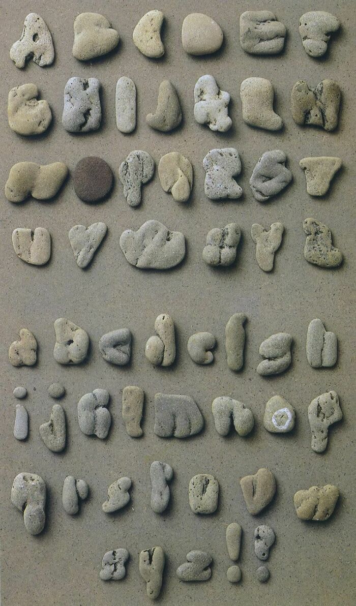 several rocks are arranged in the shape of letters and numbers on a surface with sand