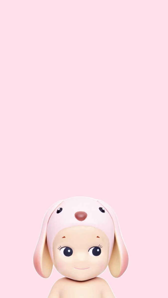 a small toy dog sitting on top of a pink floor next to a white wall