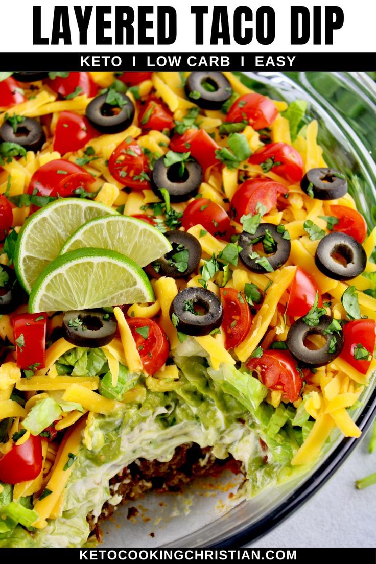 this layered taco dip is loaded with cheese, lettuce, black olives and tomatoes