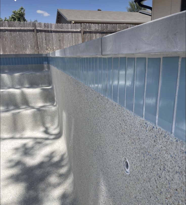 an outdoor swimming pool with blue glass tiles