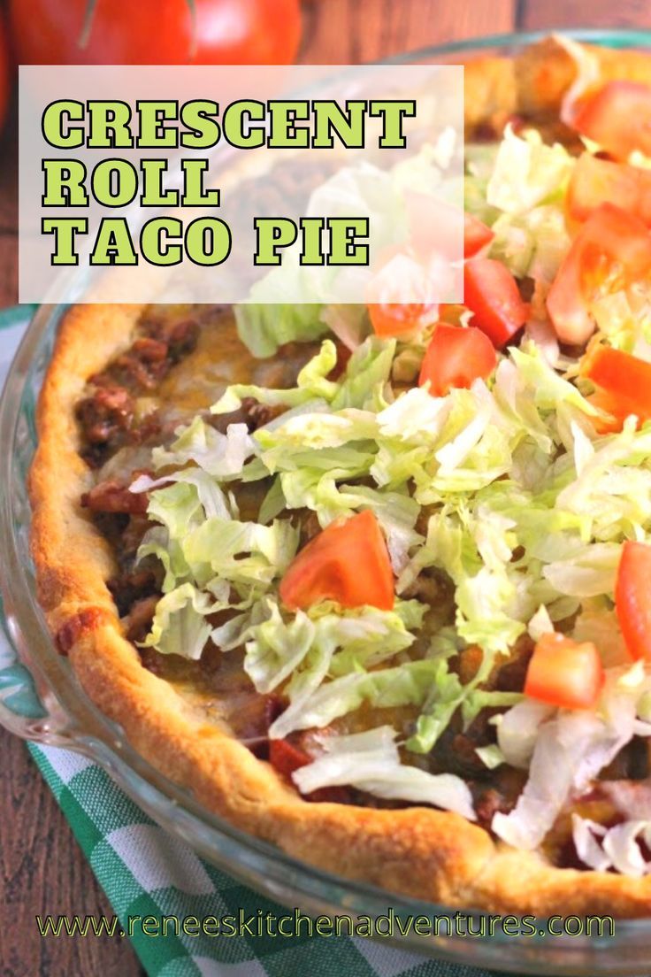 a close up of a taco pie on a table with tomatoes and lettuce