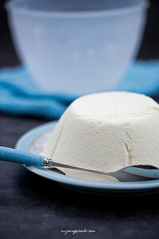 a cake on a blue plate with a fork and bowl in the backgroud