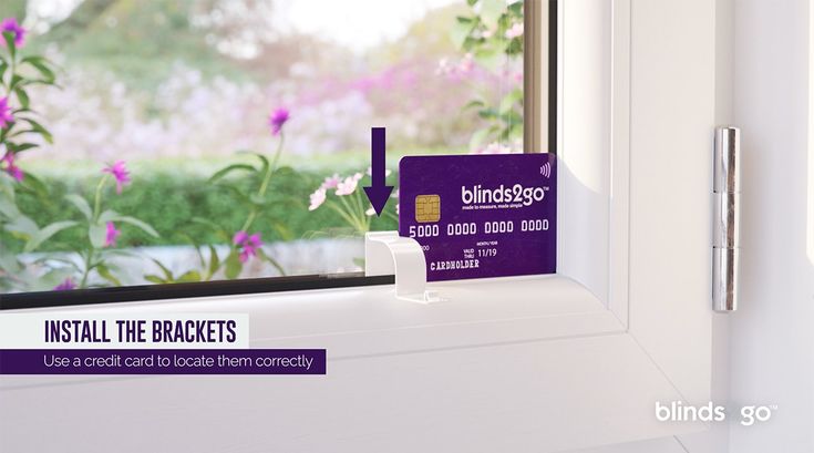 a purple business card sitting on top of a window sill in front of flowers