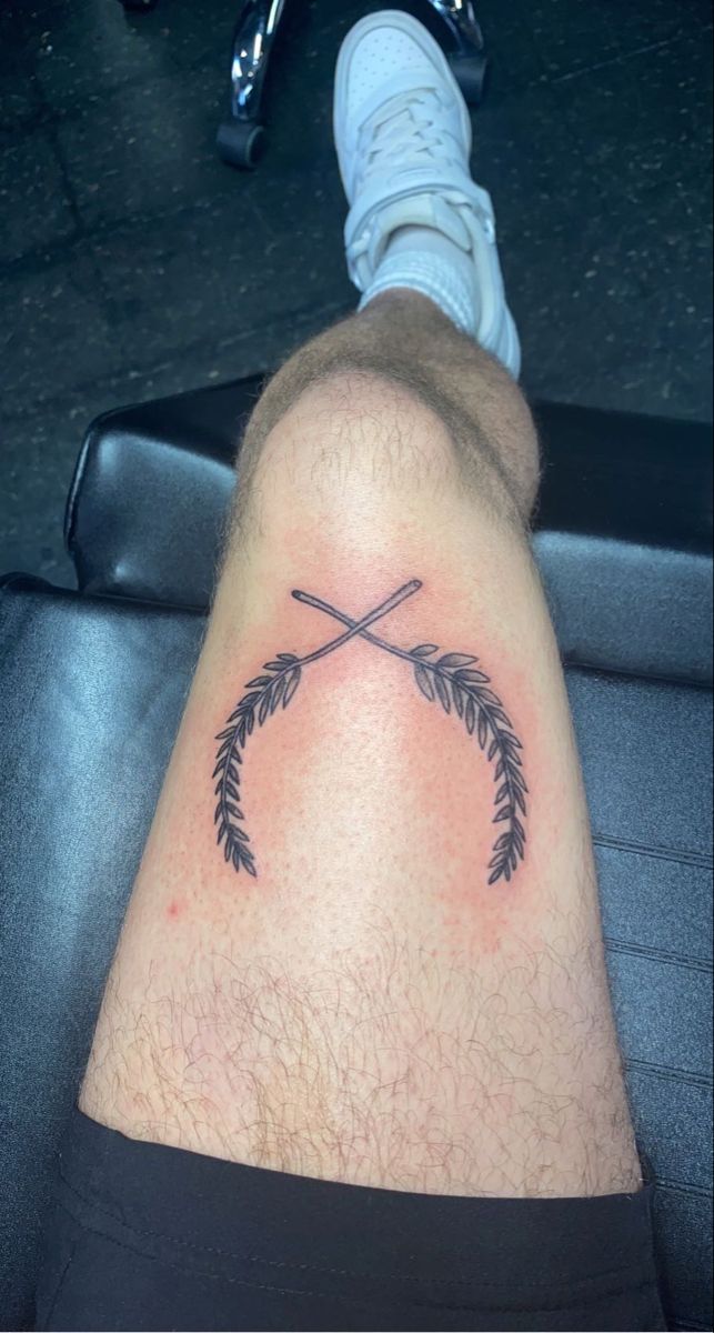 a man's leg with a tattoo on it and an arrow in the middle