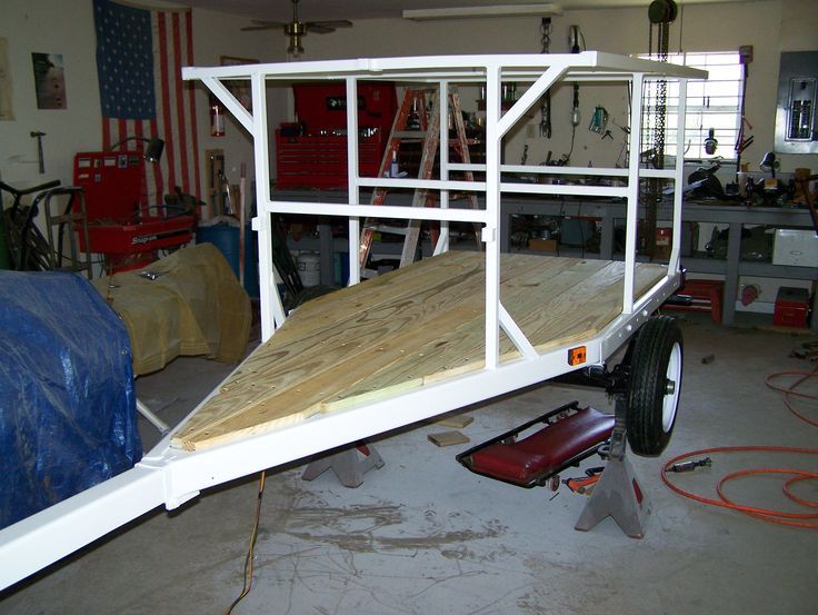 there is a truck with a ramp attached to it in the garage and tools are on the floor