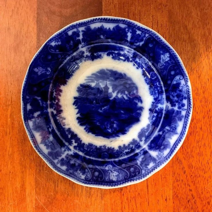 a blue and white plate sitting on top of a wooden table