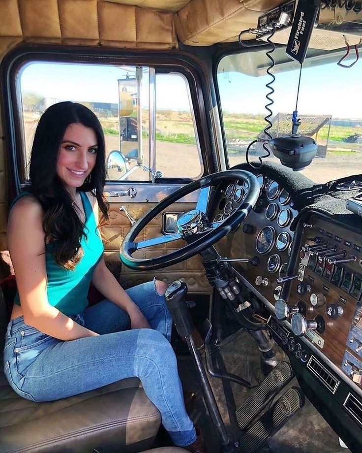 a woman sitting in the driver's seat of a truck