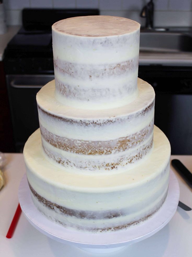 a three tiered cake sitting on top of a white plate next to a knife