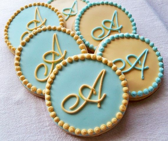 four decorated cookies with scissors and letters on them