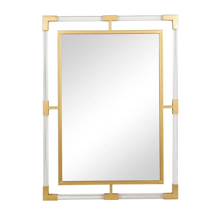 a white and gold framed mirror sitting on top of a table