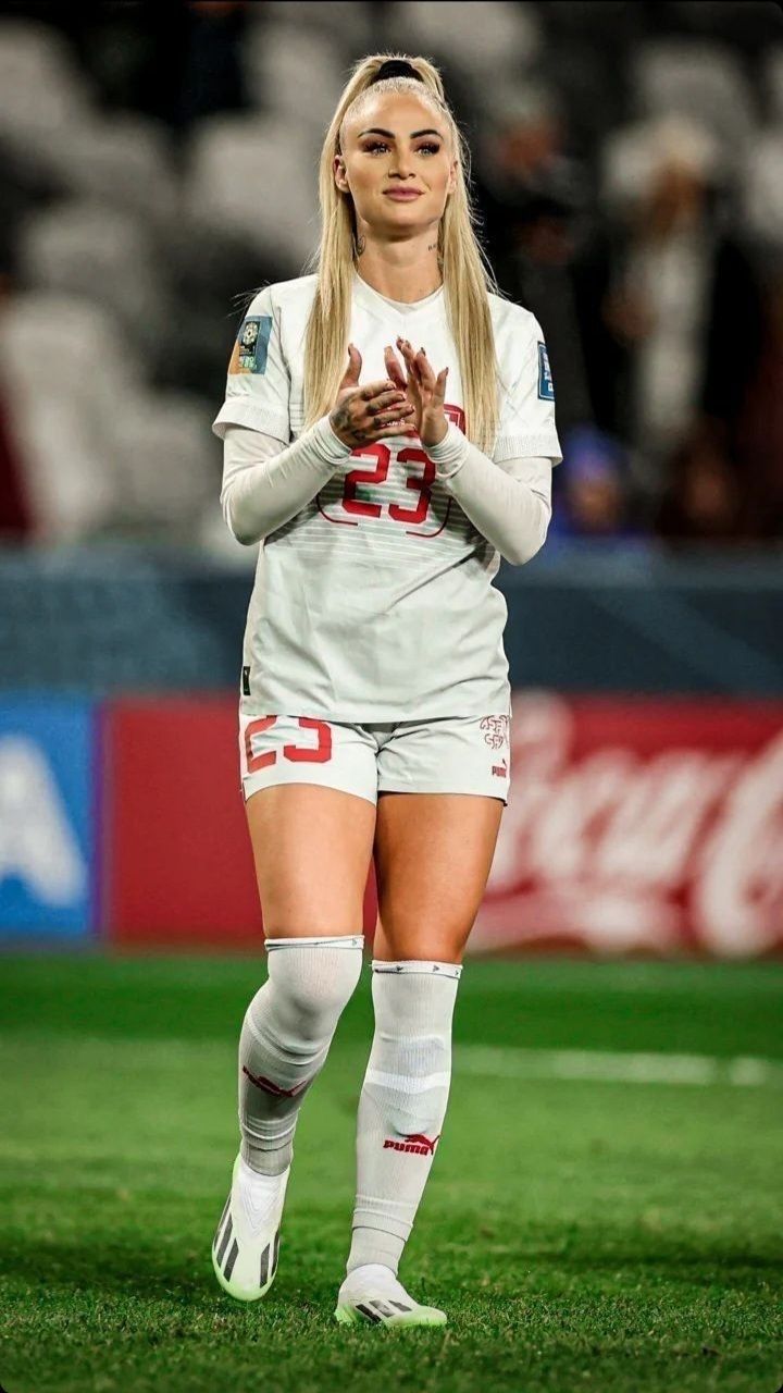 a female soccer player is standing on the field