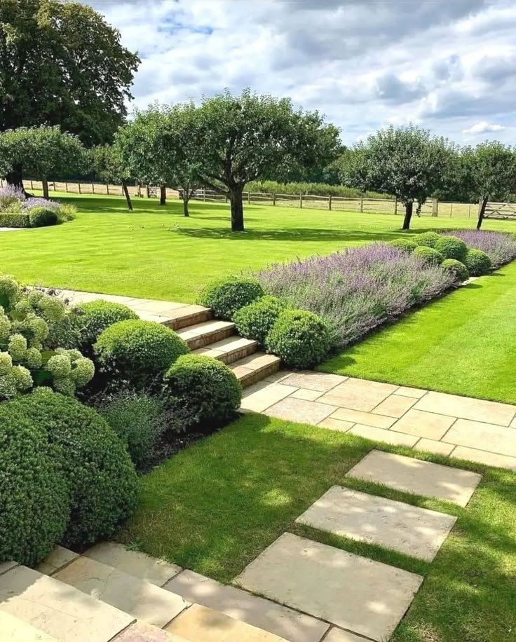 a garden with stone steps and green grass