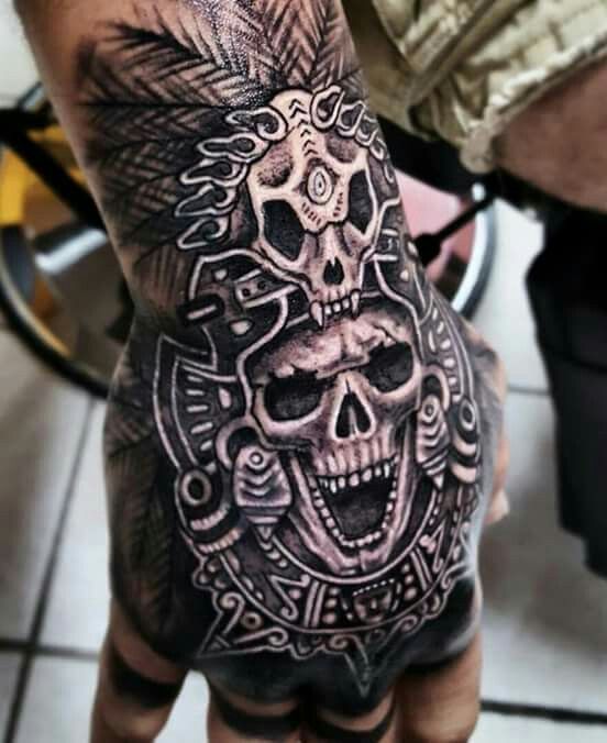 a man's hand with a tattoo on it and a skull in the middle