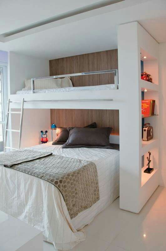 there is a bunk bed with built in shelves on the bottom and top, next to a window