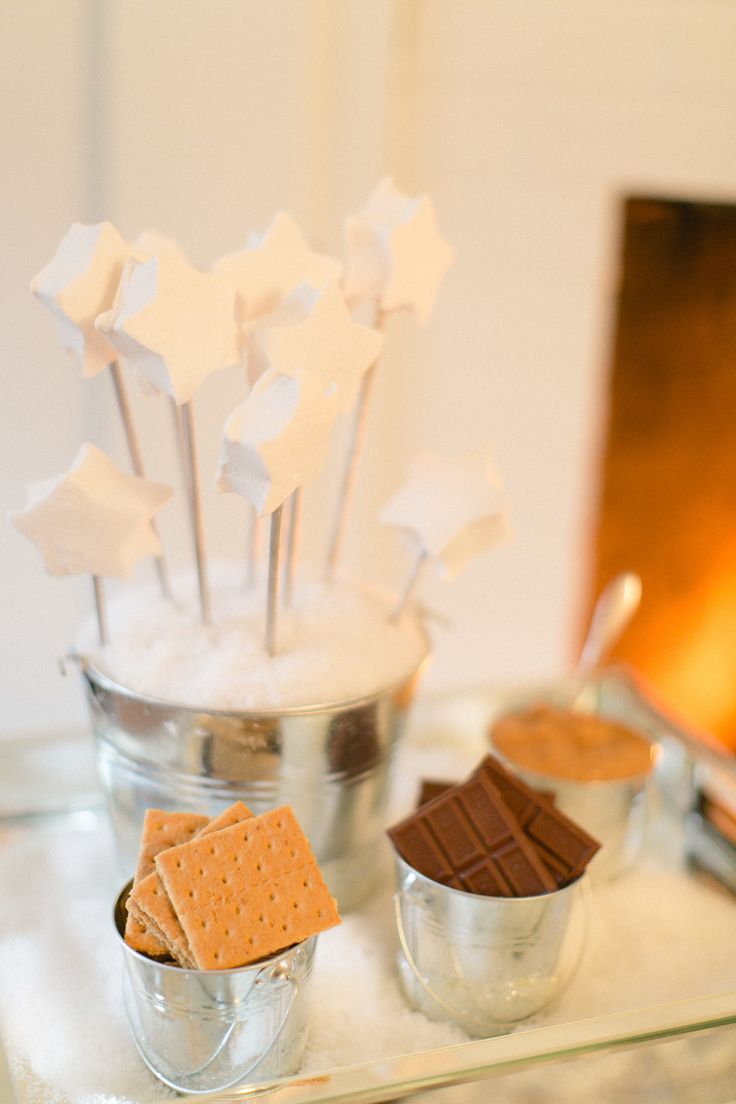 desserts are arranged on a silver tray with marshmallows and crackers