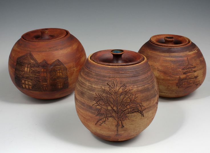 three vases with designs on them sitting next to each other in front of a white background