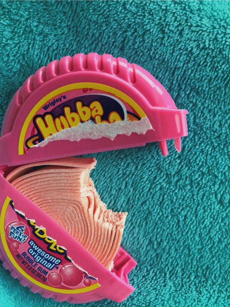 a close up of a pink plastic object on a blue towel with the word mudba written on it