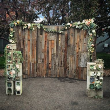 a wooden gate decorated with flowers and greenery