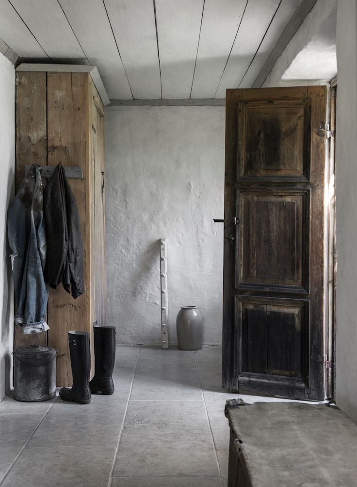 an empty room with two wooden doors and a coat rack