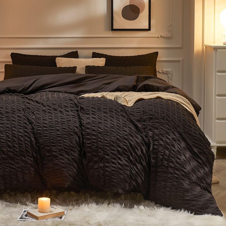 a bedroom with a bed, night stand and candles on the floor in front of it