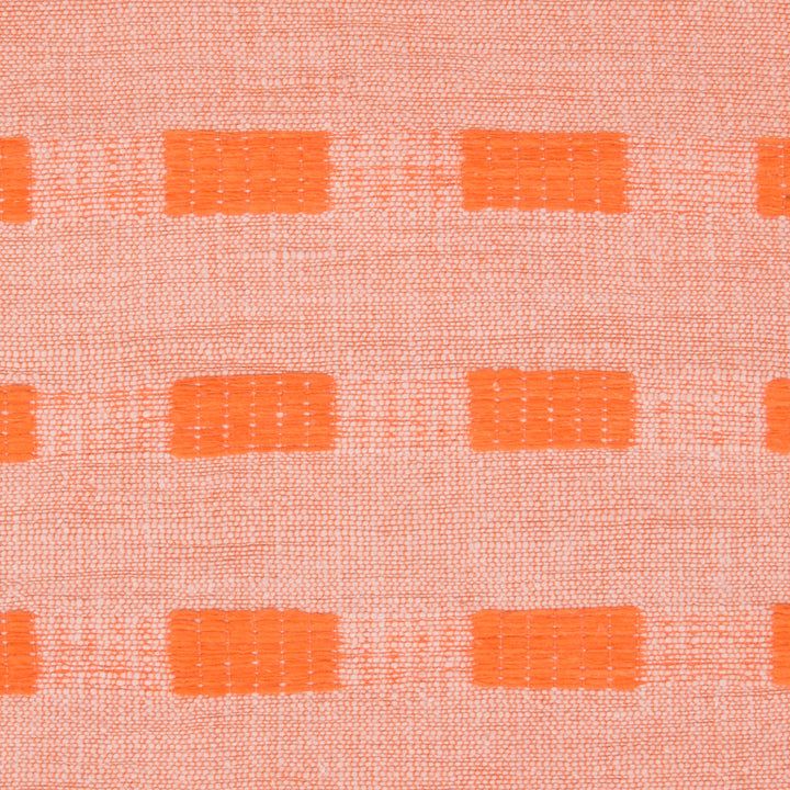 an orange and white fabric with small squares on the top of it, as well as some smaller dots