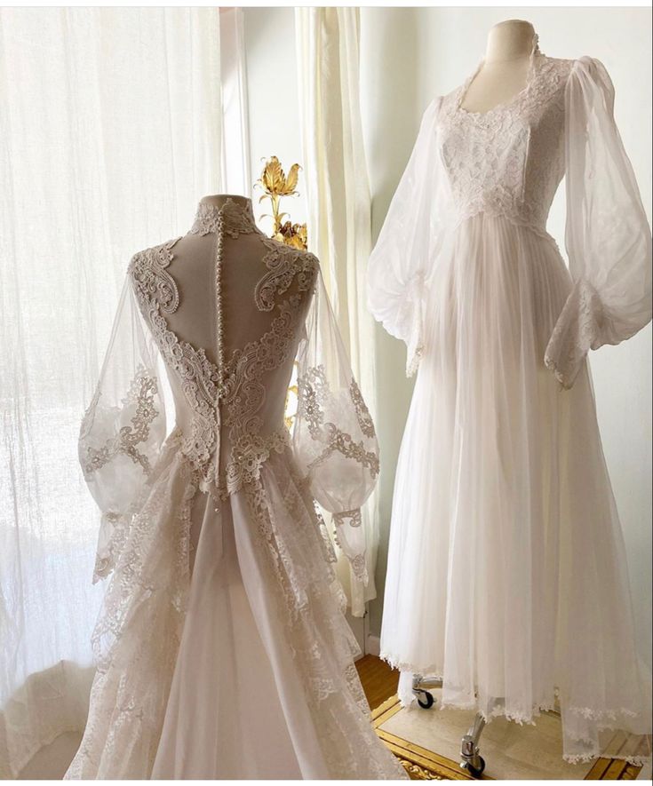 two wedding gowns on display in front of a window