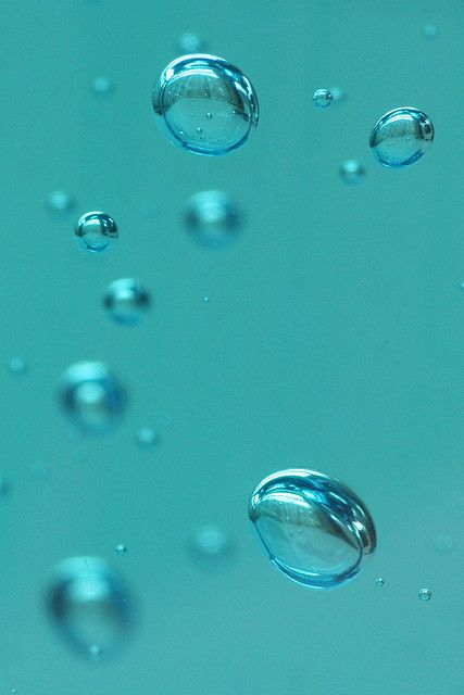 water bubbles floating in the air on a blue surface