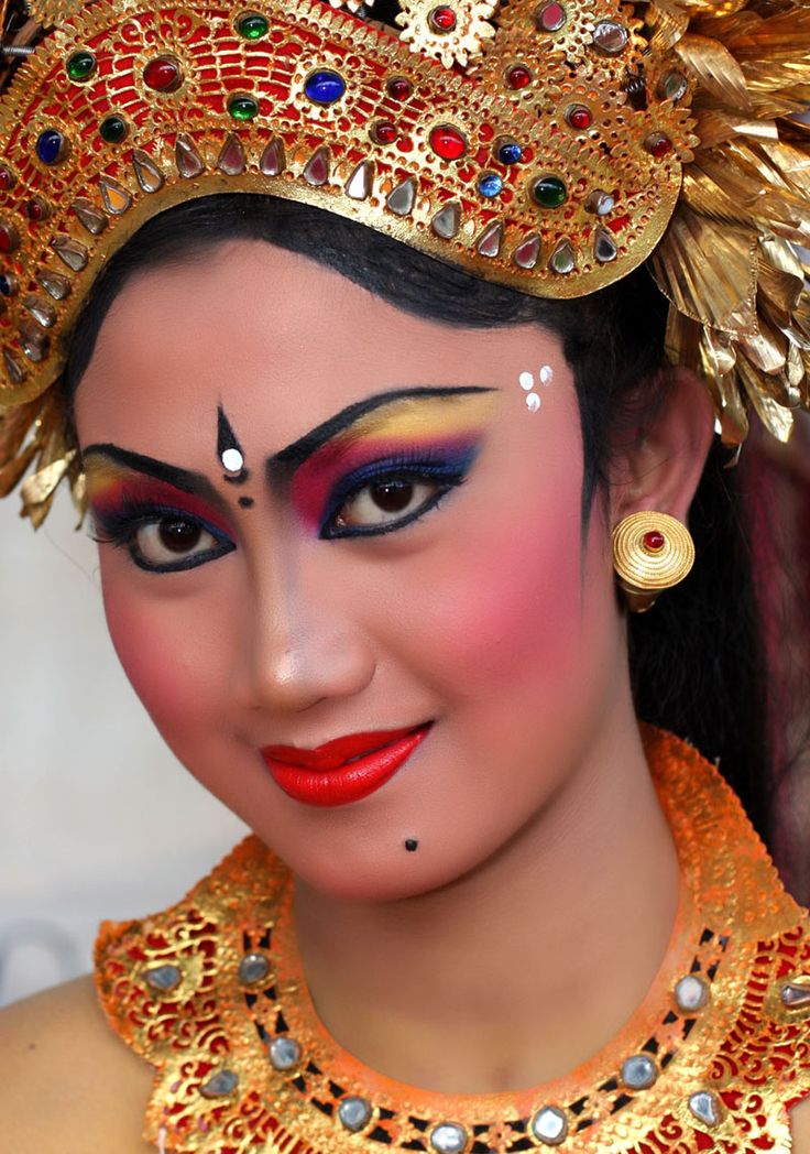 a close up of a person wearing a costume and makeup with gold jewelry on her head