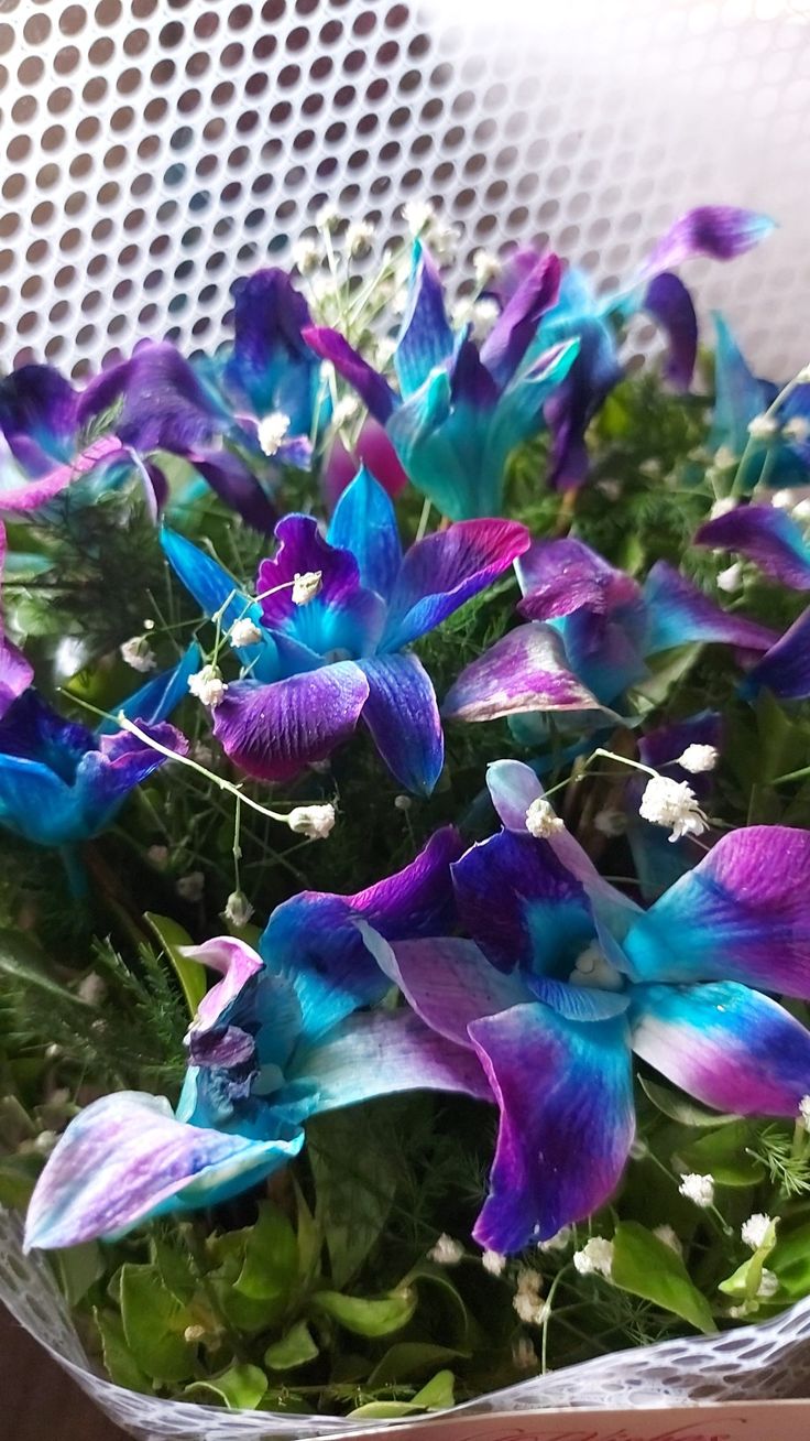 purple and blue flowers are in a basket