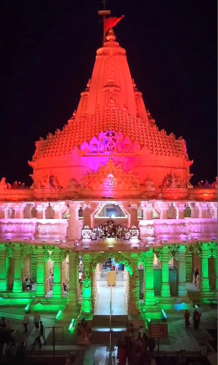 an ornate building lit up with green and pink lights