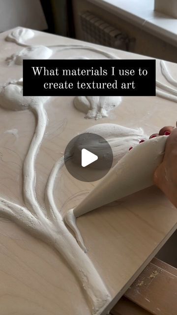 a person is working on an art project with white paint and wood shavings