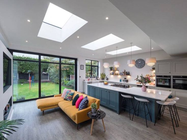 an open kitchen and living room with skylights