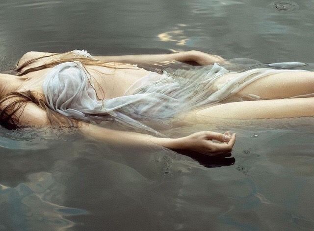 a woman is floating in the water with her head down