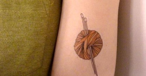 an arm with a needle and ball of yarn on the left side of the arm